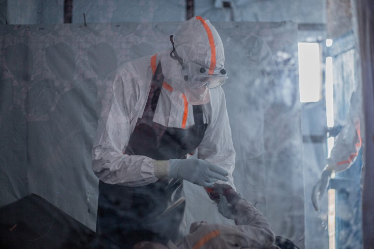 A doctor in a protective gear provides care to a patient.