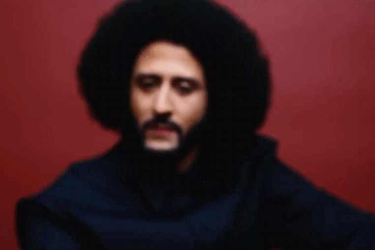 Moving image of Colin Kaepernick, out of focus, turning to look at the camera, in focus.