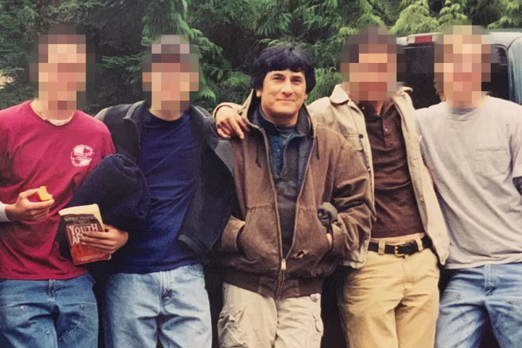Savala poses with Eli Stewart and other young followers in Alaska in 2002.