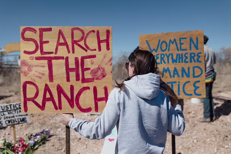 A protestor holds signs a she gathers with others outside Zorro Ranch during a rally on Women’s Day in Stanley, NM on March 8.