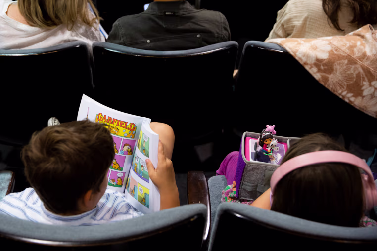 A child holds a Garfield comic book during an LAUSD board meeting in Los Angeles, on April 21, 2026.