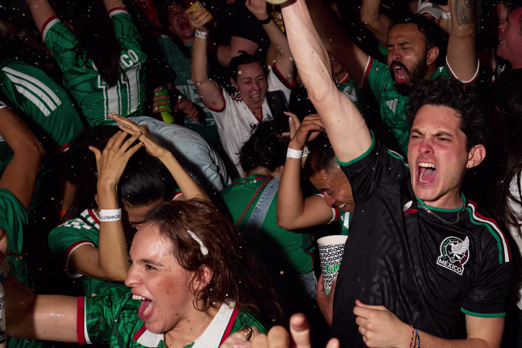 Image: Mexico football fans celebrate, spraying bottles of alcohol