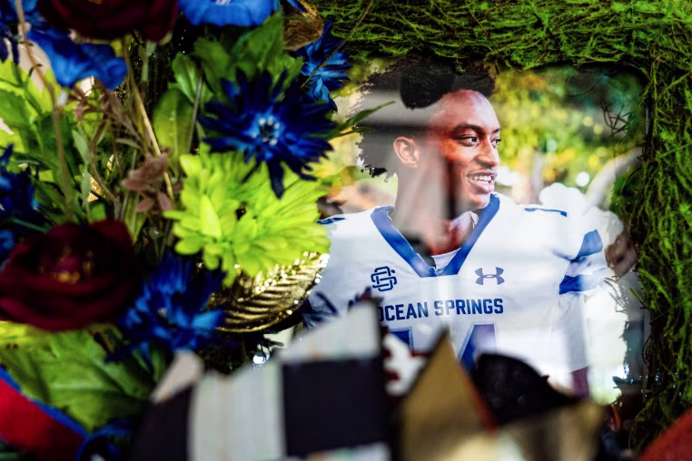 A photo of Nolan Wells surrounded by flowers 