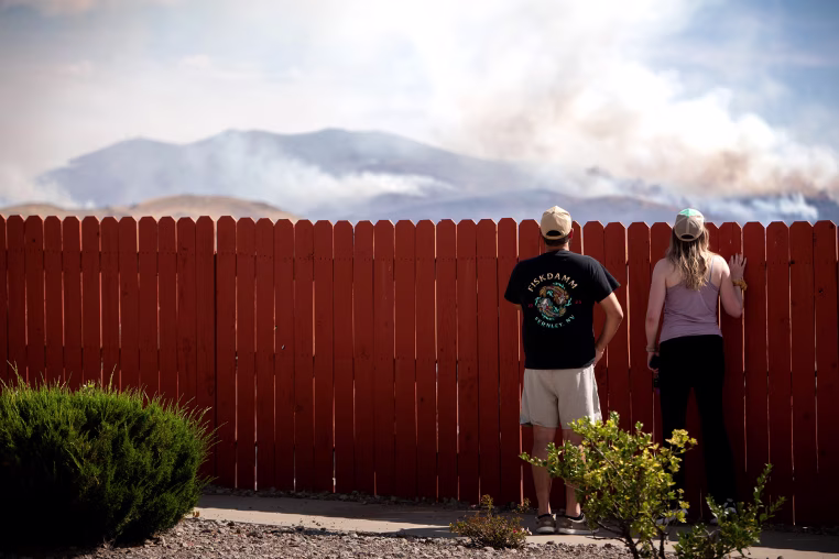 Residents look at the Hawk Fire burning on Aug. 23, 2026 in Reno, Nev.