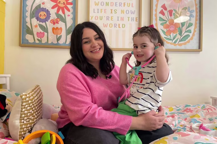 Image: Sofii Lewis holding her daughter Evie, both smiling