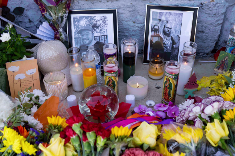 A memorial with two photographs, candles and flowers sits outside Venture-N Bar in Tucson.