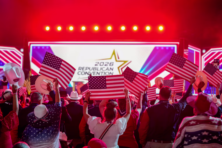 Attendees hold American flag placards during the Republican Midterm Convention.