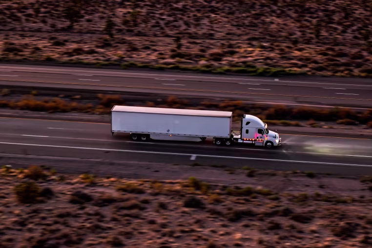 White Semi-truck Crossing Mojave Desert Near California-Nevada Border - High Angle, Aerial