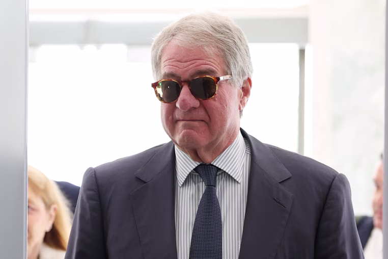 Leon Black walks through a security scanner at the Capitol