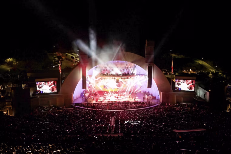 A wide view of the Hollywood Bowl from the back of the crowd at night.