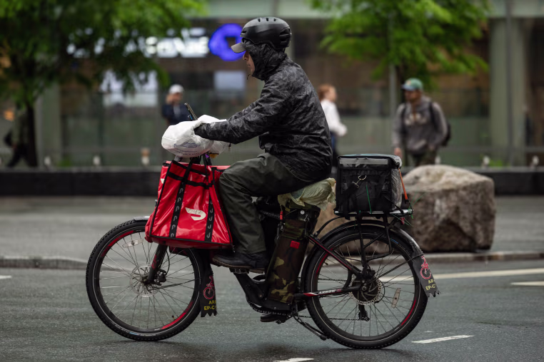 A DoorDash delivery worker rides a bike New York.