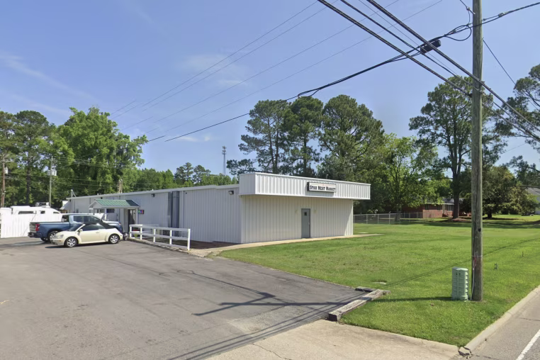 A Google street view of a one-story building with white siding.