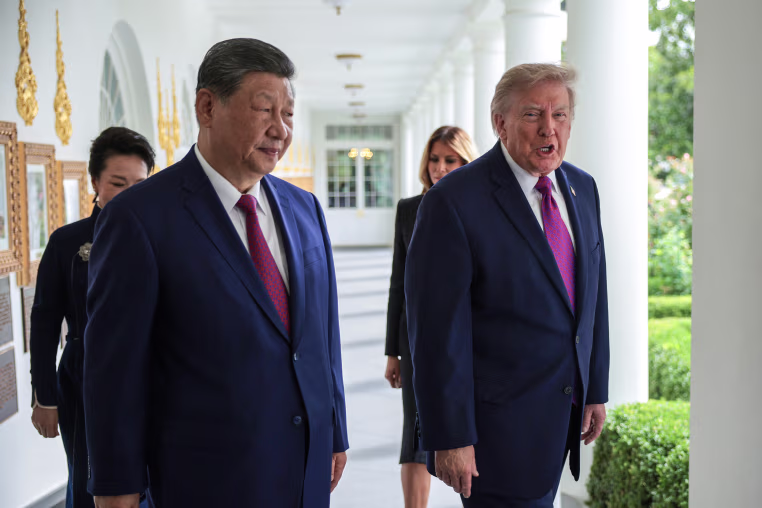 President Trump and President Xi Jinping walking along the White House colonade with their wives behind them.