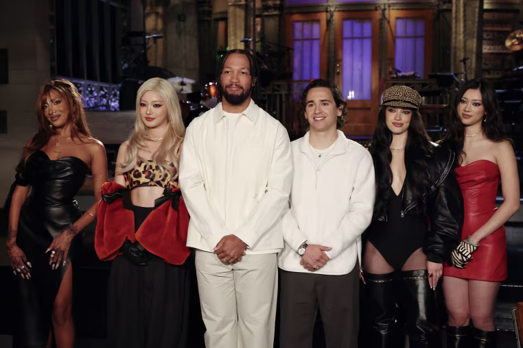 A group portrait of Jalen Brunson and Katseye on stage during an SNL taping.