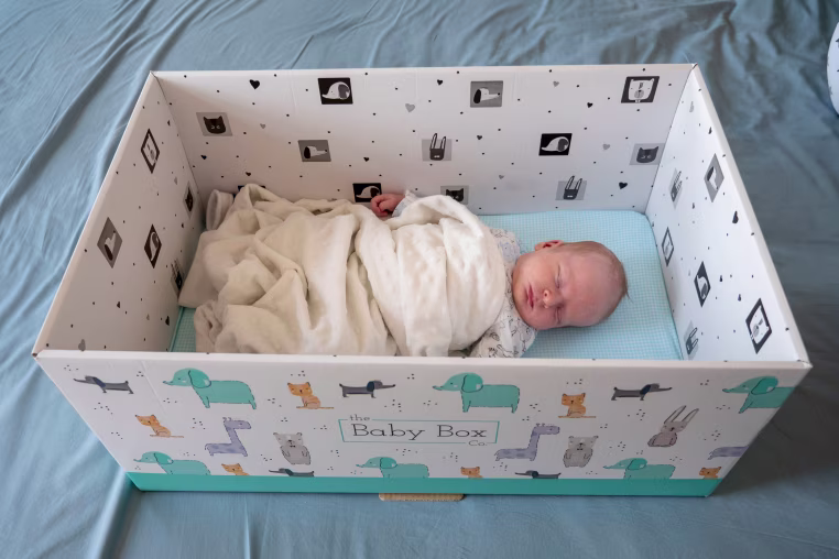 Newborn baby sleeping in a baby box