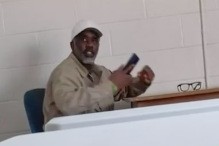Diddy seated at a table holding a cellphone