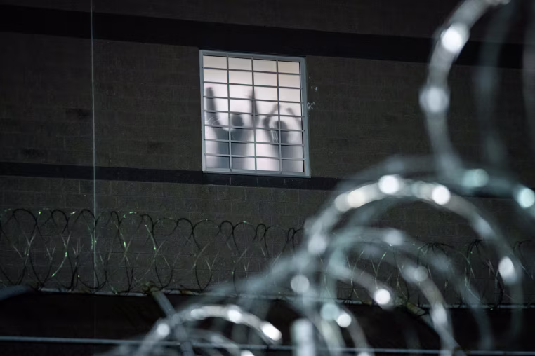 Detainees stand by a window at Delaney Hall, an ICE facility in Newark, N.J., on May 26, 2026.