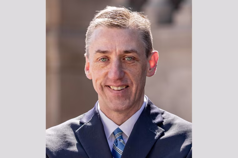 A headshot of Matthew Van Houten, standing outside