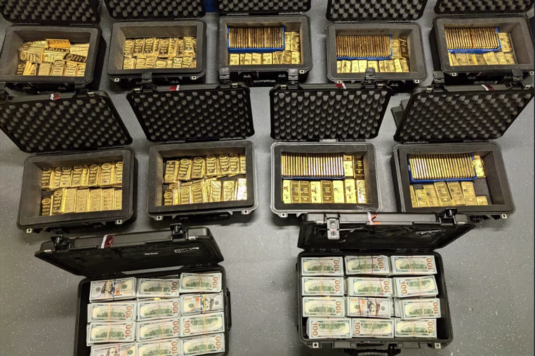 Black briefcases filled with gold bars and stacks of 100 dollar bills
