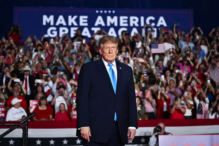 President Donald Trump at a campaign rally in Nebraska, standing in front of a crowd of people.