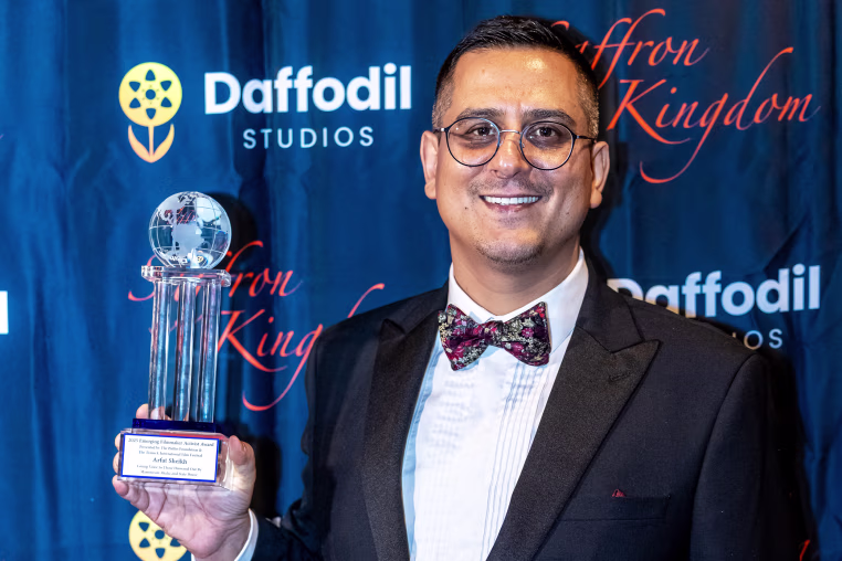 Arfat Sheikh holding an award.