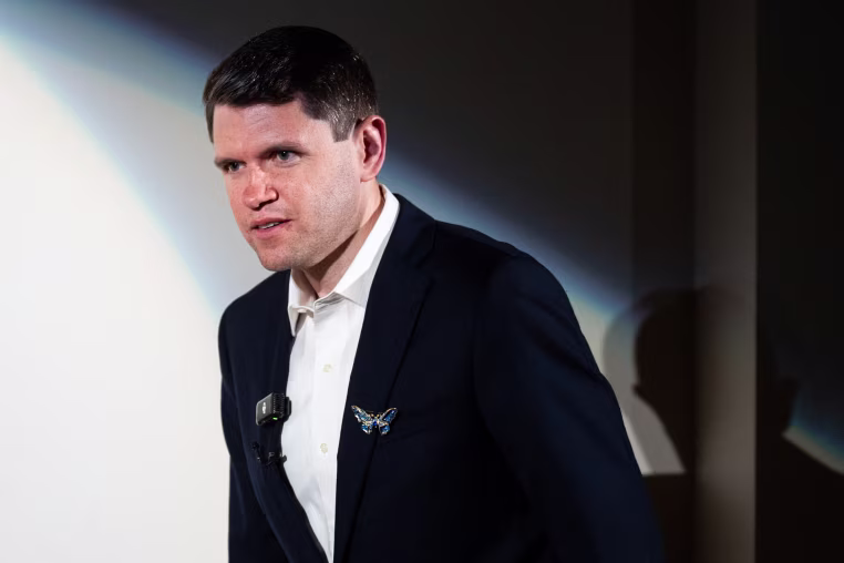 James Talarico stands on stage with a spotlight on him