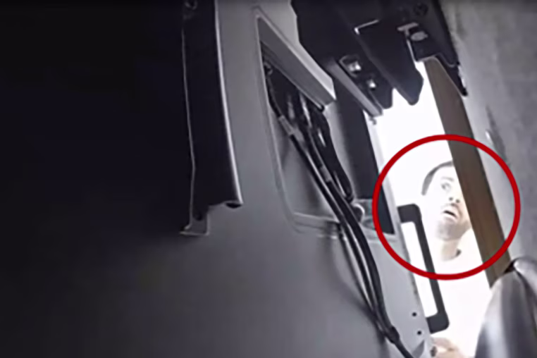 Image: A screenshot of footage of Alfozan looking behind a TV.