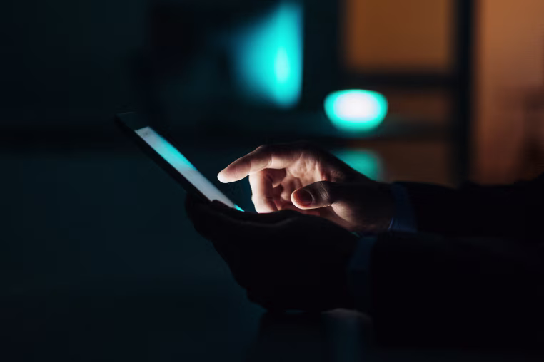 Image: Close-up of a man using a touchscreen phone.