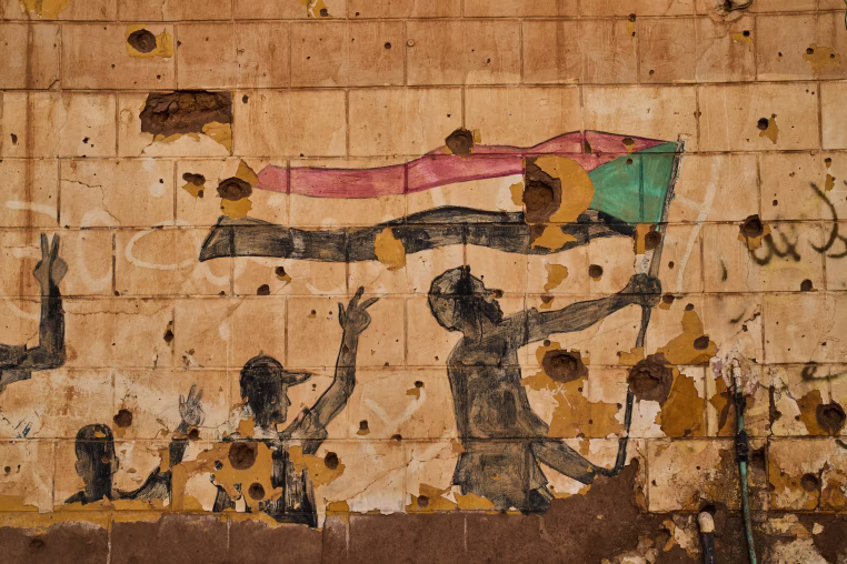 A painting depicting people holding the Sudanese flag.
