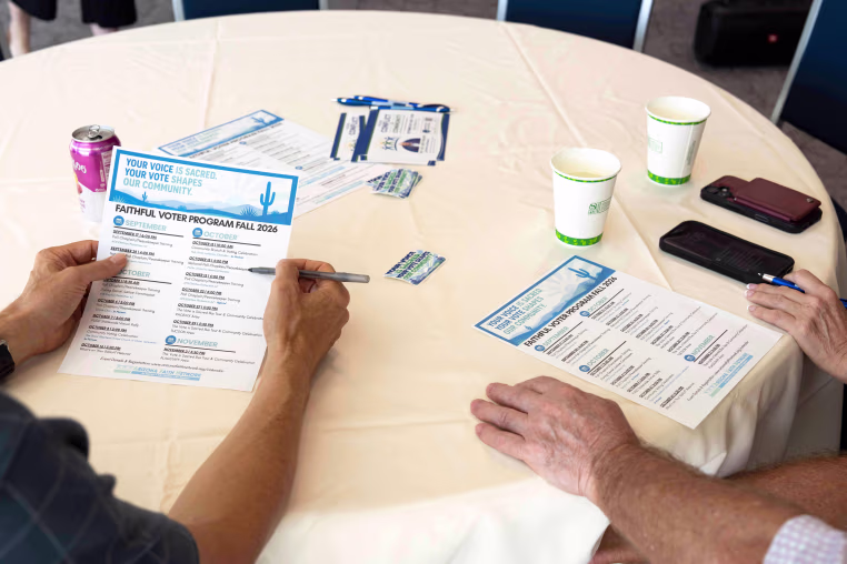El reverendo Dan Hoeger y Brad Weintraub repasan una lista de próximos eventos durante una capacitación organizada por Arizona Faith Network para capellanes electorales y agentes de paz, el 6 de octubre de 2026, en Scottsdale, Arizona. 