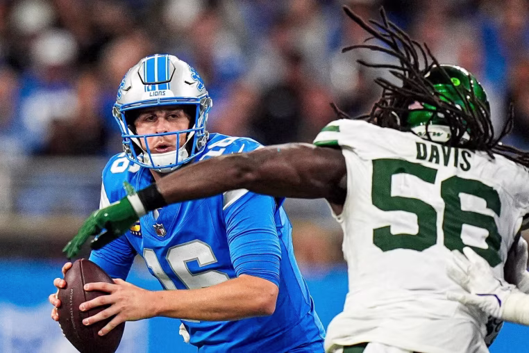 Detroit Lions quarterback Jared Goff (16) looks to pass against New York Jets linebacker Demario Davis (56) during the second half at Ford Field in Detroit on Sunday, Sept. 27, 2026.