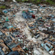 Image: People walk through a neighbor destroyed by Hurricane Dorian at Marsh Harbour in Great Abaco Island, Bahamas