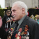 FILE  - In this Friday, May 8, 2015 file photo, Soviet war veteran David Dushman, 92, center, speaks to people holding Ukrainian flags as he attends a wreath laying ceremony at the Russian War Memorial in the Tiergarten district of Berlin, Germany. Dushman, the last surviving Allied soldier involved in the liberation of Auschwitz, has died. The Jewish Community of Munich and Upper Bavaria said Sunday, June 6, 2021 that Dushman had died a day earlier in a Munich hospital at the age of 98. As young Red Army soldier, Dushman flattened the forbidding fence around the notorious Nazi death camp with his tank on Jan. 27, 1945. (AP Photo/Markus Schreiber, File)