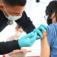 An emergency medical technician gives a second dose of the Pfizer Covid-19 vaccination to a teen in Los Angeles on Aug. 23, 2021.
