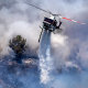 A helicopter makes an aerial drop at the the Chaparral Fire in Murrieta, Calif., on Aug. 29, 2021.