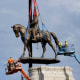 The statue of Robert E. Lee is lowered from its pedestal on Sep. 8, 2021 in Richmond, Va.