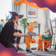 Mother and baby son in costumes at home for Halloween, and the pet dog in costume too