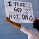 A protestor opposing Covid-19 vaccine mandates holds a sign in front of City Hall in downtown Los Angeles on Sept. 18, 2021.