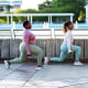 Two African-American woman doing lunges in city park