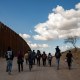 IMage: A group of migrant families from Central America walk near the border wall between the United States and Mexico near Sasabe, Ariz., on Jan. 23, 2022.