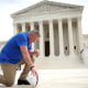 Image: Joe Kennedy kneeling before the Supreme Court.