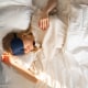 Woman with eye mask sleeping in bed at home