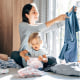 Smiling Mother And Daughter Folding Clothes At Home