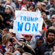 Image: A person in the crowd holding a sign that reads,\"Trump Won\".