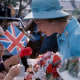 Image: Queen Elizabeth II talking to children in the crowd assembled to greet her.