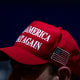 Image: A supporter at a rally wearing a red hat that reads,\"Make America Great Again\".
