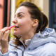 Woman putting on chapstick, outside