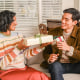 Woman passing a gift to a man in a living room