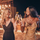 Two beautiful women in evening gowns dancing and smiling