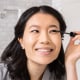 Woman applying mascara